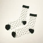 Flat view of transparent socks with small raised black dots and black toe heel and cuff