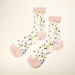 Transparent socks with pink toe heel and cuff scattered with fuzzy multicolor dots