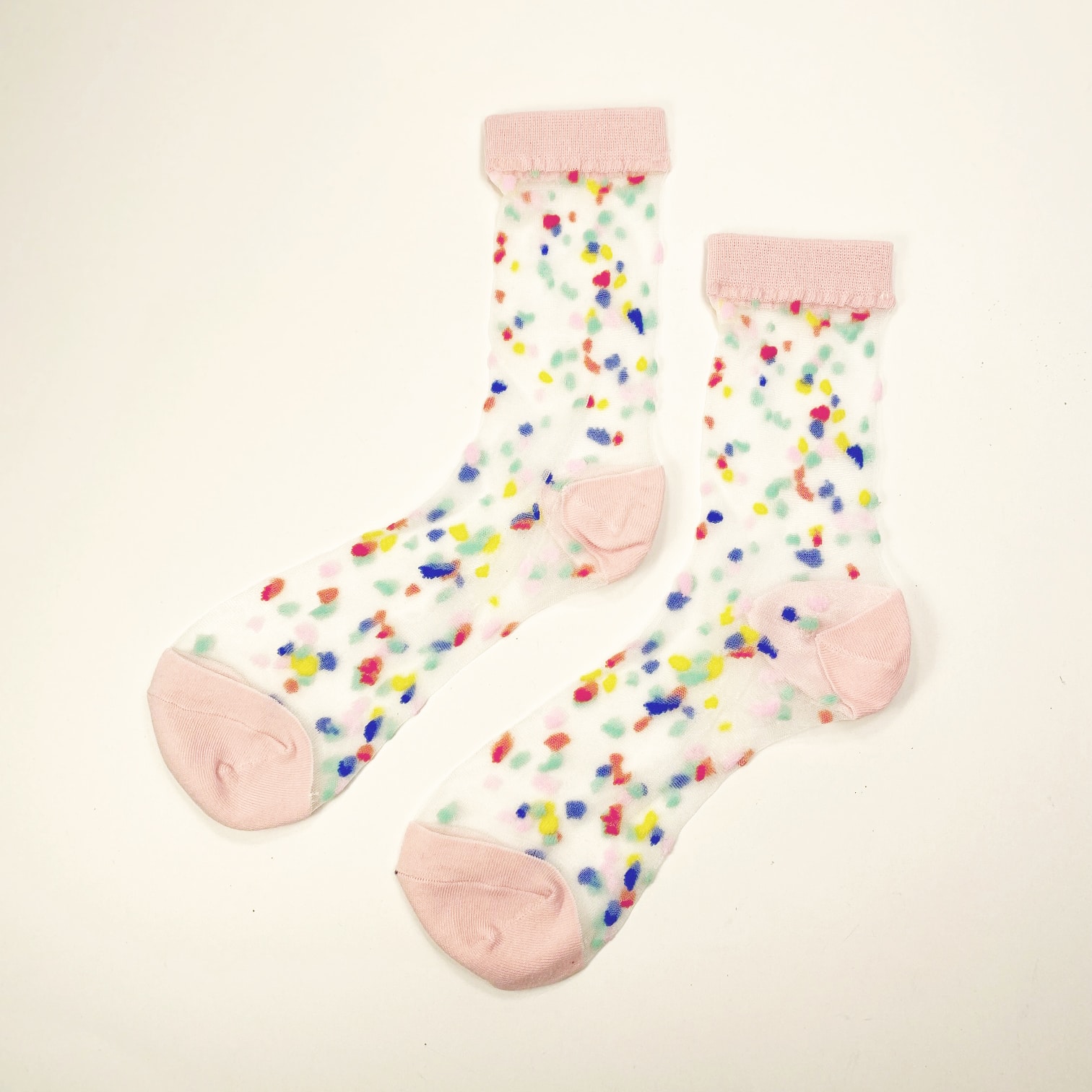 Transparent socks with pink toe heel and cuff scattered with fuzzy multicolor dots