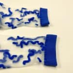 Pair of sheer socks with abstract blue squiggle lines and blue accents