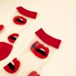 Detailed view of red lips pattern on sheer socks with red cuff