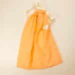 Peach colored cotton dust bag for shoes tied with ivory satin ribbon