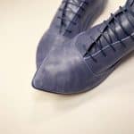 Angled close-up of blue leather pointed-toe lace-up shoes, handmade in Italy