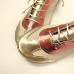 Handmade trainers in metallic gold and coral Italian leather angled view