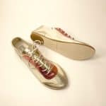 andmade Italian leather trainers in metallic gold and coral showing soles